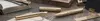 A collection of brass writing instruments and accessories arranged on a textured surface. Produktbild-Vorschau