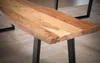 A close-up view of a wooden bench with black metal legs, resting on a textured rug. Náhled obrázku produktu