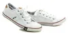 A pair of white canvas sneakers with red and blue accents, shown against a white background. Produktbild-Vorschau