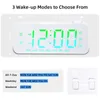 A digital alarm clock displaying the time and days of the week, with accompanying text describing wake-up modes. Produktbild-Vorschau