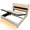 A beige upholstered bed frame with its mattress support mechanism partially lifted, revealing storage space underneath. The bed features integrated LED lighting along the base and headboard. Produktbild-Vorschau