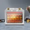 A stainless steel food dehydrator filled with various food items is displayed on a marble countertop. Podgląd zdjęcia produktu
