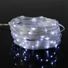 A coil of white LED string lights on a black reflective surface. Produktbild-Vorschau