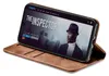 A smartphone with a movie playing on its screen is propped up in a brown leather flip case. Produktbild-Vorschau