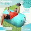 A man is exercising on an inflatable air roll outdoors on the grass. Produktbild-Vorschau