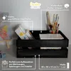 A black wooden crate filled with art supplies, including paintbrushes and canvases, placed on a desk next to a painting on an easel. Produktbild-Vorschau