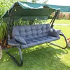 A garden swing with a green canopy and gray cushions is set up on a lawn, surrounded by plants and a manicured garden. Anteprima dell’immagine prodotto