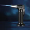 A black and silver gas torch with a blue flame against a dark blue background. Náhled obrázku produktu
