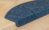 A close-up view of a blue carpet stair tread on a wooden step. Produktbild-Vorschau