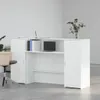 A white reception desk with a laptop and books on it, in a minimalist office setting. Náhľad obrázku produktu