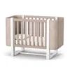 A baby crib with a mattress and pillow, shown from the front on a white background. Produktbild-Vorschau