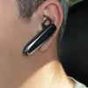A close-up shot of a person's ear with a black and silver Bluetooth headset. Náhled obrázku produktu