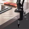 A desk clamp for a lamp is shown attached to the edge of a wooden desk. Produktbild-Vorschau