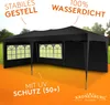 A black pop-up tent with windows, set up outdoors with a grassy and treed background, and an orange gradient foreground with text. Produktbild-Vorschau