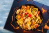 A close-up overhead view of a pan filled with a colorful vegetable stir-fry, placed on a decorative mat with glowing orange lines. Náhľad obrázku produktu