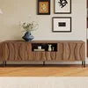 A wooden TV stand with decorative doors and a central open shelf, adorned with a vase of flowers and decorative figurines, set against a neutral wall with framed artwork. Anteprima dell’immagine prodotto