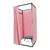 A pink changing room with a black and white checkered stool and two white high-heeled shoes inside. Voir les images du produit