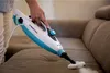 A person is using a handheld steam cleaner on a sofa. Náhled obrázku produktu