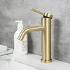 A close-up shot of a gold-colored faucet with water running into a sink. A white soap dispenser is visible in the background. Anteprima dell’immagine prodotto