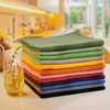 A stack of colorful kitchen towels on a countertop with a blurred kitchen background. Produktbild-Vorschau