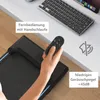 A person's hand holding a remote control over a treadmill, with a keyboard and laptop in the background. Produktbild-Vorschau