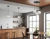 A modern kitchen and dining area with pendant lights, wooden cabinets, and a round dining table. Produktbild-Vorschau