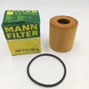 A product shot of a MANN FILTER oil filter and its packaging, along with a rubber gasket, on a white background. Voir les images du produit