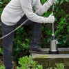 A person is holding a submersible pump with a rope. Produktbild-Vorschau