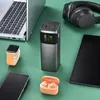 A collection of electronic devices including a laptop, power bank, headphones, smartwatch, smartphone, and earbuds, arranged on a green surface. Produktbild-Vorschau