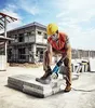 A construction worker is using an angle grinder to cut concrete blocks on a construction site. Podgląd zdjęcia produktu
