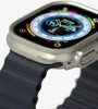 Close-up of a smartwatch with a dark blue strap and a silver-tone case, showing the watch face with a compass and altitude display. Náhled obrázku produktu