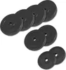 A collection of black weight plates stacked in groups against a white background. Náhled obrázku produktu