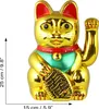 A golden Maneki-neko (waving cat) figurine with red and green accents, holding a fish. Produktbild-Vorschau