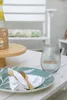 A table setting with a plate, cutlery, napkin, and a glass of water. Anteprima dell’immagine prodotto