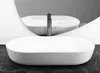 A white oval basin sink with a chrome faucet is shown in a bathroom setting, with a large curved mirror reflecting the sink. Produktbild-Vorschau