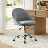 A grey office chair in a well-lit room with a desk and flowers in the background. Náhled obrázku produktu