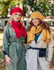 Two women wearing winter hats and scarves in an outdoor setting. Anteprima dell’immagine prodotto