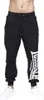 A person is wearing black sweatpants with a white logo on the left leg and white sneakers. Produktbild-Vorschau