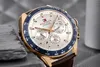 A close-up shot of a Tommy Hilfiger watch with a white dial, gold casing, and a blue bezel, set against a textured gray background. Anteprima dell’immagine prodotto