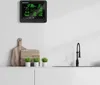 A weather station is mounted on a wall above a kitchen counter with cutting boards and small plants. Anteprima dell’immagine prodotto