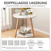A small round side table with two shelves, decorated with a vase of flowers, a cup, and books. Produktbild-Vorschau