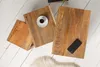 Three wooden side tables of different sizes placed on a white wooden floor. Produktbild-Vorschau