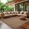 An outdoor living space with a sectional sofa and a rug. Produktbild-Vorschau