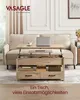 A lift-top coffee table is shown in a living room setting, with a laptop and cup on top, and storage compartments below. Produktbild-Vorschau