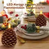 A festive table setting with Christmas decorations, including pinecone-shaped LED candles. Produktbild-Vorschau