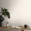 A desk with a book, mug, and plant. Produktbild-Vorschau
