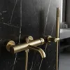 A close-up view of a gold-colored bathtub faucet and showerhead mounted on a black marble wall. Anteprima dell’immagine prodotto