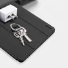 A close-up shot of a black tablet case with keys and a white power adapter resting on it. Podgląd zdjęcia produktu