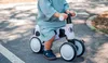 A child is riding a balance bike on a paved path. Náhled obrázku produktu
