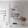 A bathroom scene featuring a medicine cabinet with products inside, a sink, and a towel rack. Produktbild-Vorschau